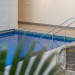 Indoor swimming pool, with a wicker chair and a fern, at Rawhiti Retirement Village.