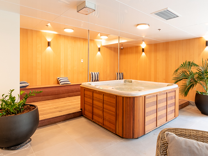 Relaxing spa area at Rawhiti Estate retirement village with wooden hot tub and cozy seating.